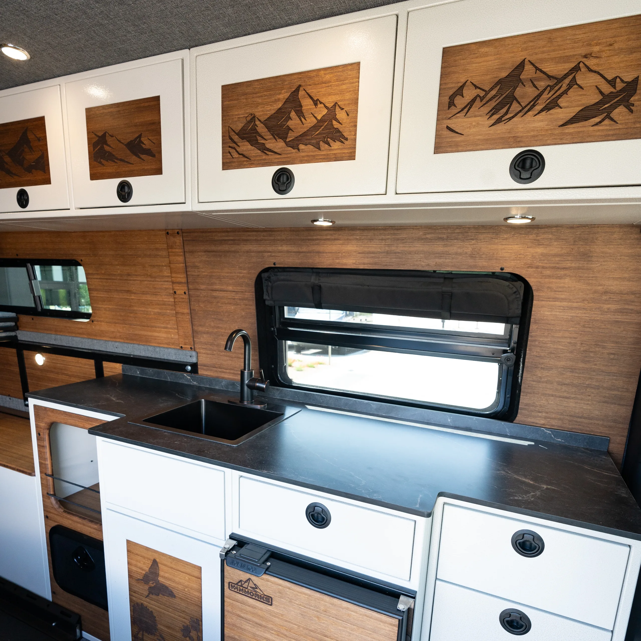 Light Premier Package (Dark-Stained Bamboo Walls, Engraved Mountain Cabinet Insets, Black Premium Thinscape Countertop, White Cabinets, and Fabric Wrapped Headliner)